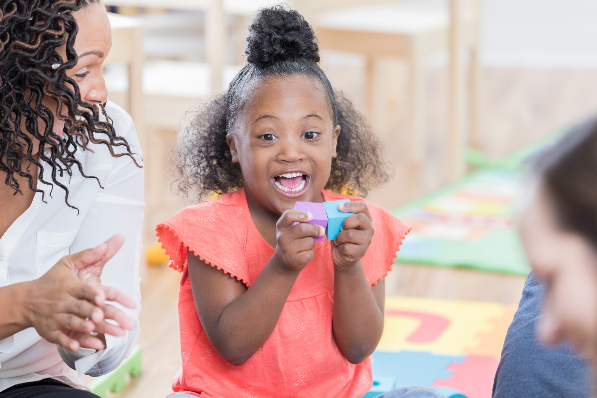 Happy girl with disability playing with toy blocks